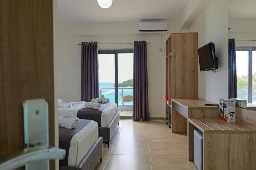 a hotel room with two beds and a television at Hotel Esmerald Ksamil in Ksamil