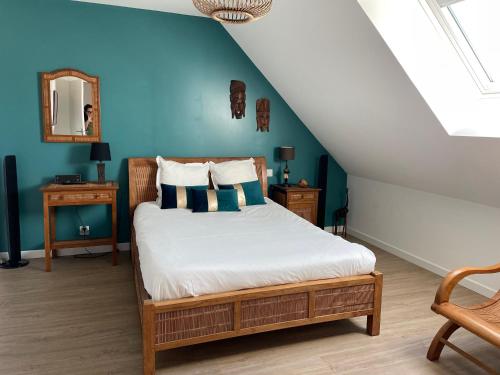 - une chambre avec un lit et un mur bleu dans l'établissement Villa Elias, pour séjours familiaux : Spacieuse, moderne, à La Baule