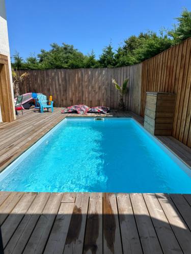 - une piscine sur une terrasse avec une clôture en bois dans l'établissement Maison de vacances au centre Biscarrosse, à Biscarrosse
