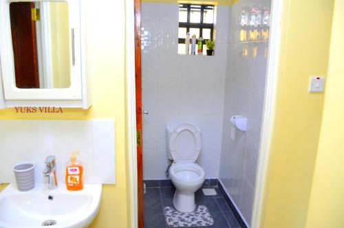 a bathroom with a toilet and a sink at Yuks Villa in Kisumu