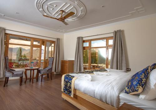 a bedroom with a bed and a table and chairs at The Nangsay Hotel in Leh