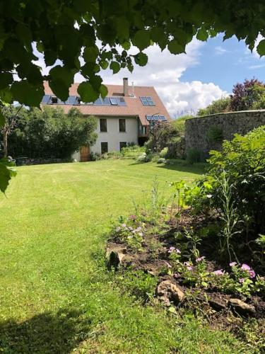 une grande cour avec une maison en arrière-plan dans l'établissement Le Presbytère - Des vacances à la montagne, à Saint-Laurent-du-Cros