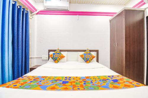 um quarto com uma cama com um edredão colorido em FabHotel The Horizon I em Lonavala