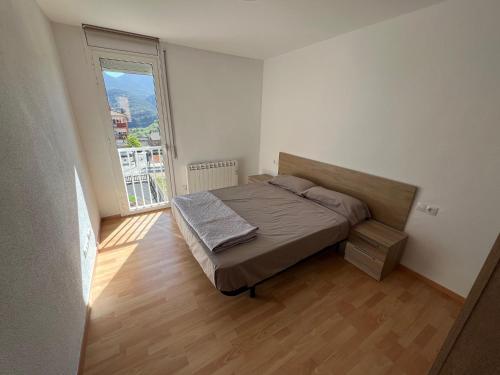 a bedroom with a bed and a large window at Apartament reformat al Berguedà in Sant Jordi de Cercs