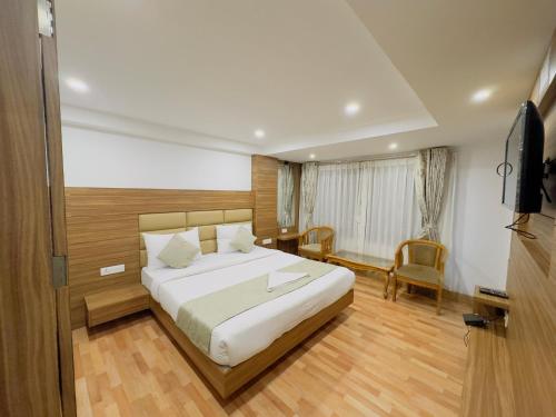 une chambre d'hôtel avec un lit et une télévision dans l'établissement Staynest darjeeling near railway station, à Darjeeling
