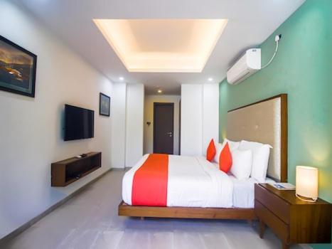 a bedroom with a large bed and a television at Okean De Goa Vagator in Vagator