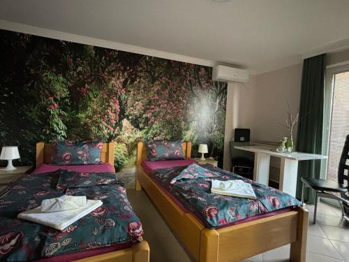 a bedroom with two beds and a wall mural at Apartmani "MARIJA" Golubac in Golubac