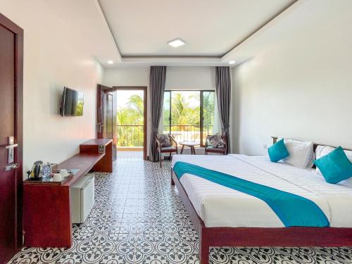 a hotel room with a bed and a balcony at Angkearboss Villa in Kampot