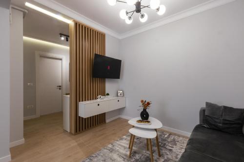 a living room with a couch and a tv on a wall at Signature TN Executive Suites in Bucharest