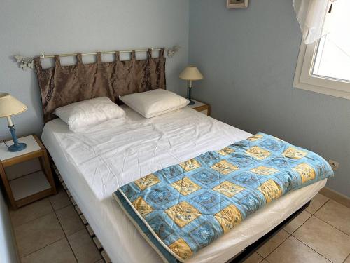 un grand lit dans une chambre avec deux lampes dans l'établissement HOLIDAYLAND VILLA T3 304 MEZZANINE 9 couchages climatisé NARBONNE PLAGE, à Narbonne-Plage