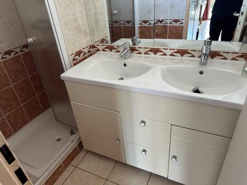 une salle de bain blanche avec deux lavabos et une douche dans l'établissement HOLIDAYLAND VILLA T3 304 MEZZANINE 9 couchages climatisé NARBONNE PLAGE, à Narbonne-Plage