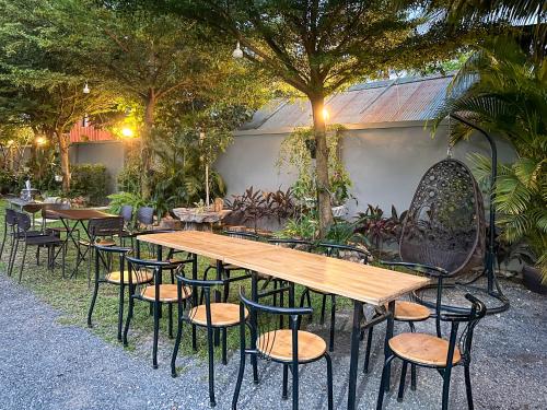 a wooden table and chairs in a garden at Angkearboss Villa in Kampot