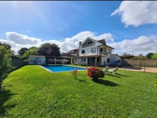 a house with a yard with a swimming pool at Amplia casa familiar in Pontevedra