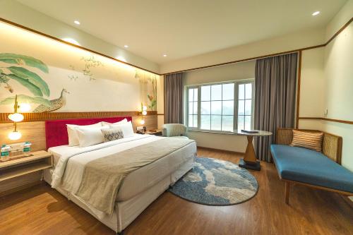 a hotel room with a bed and a desk at Nidhivan Sarovar Portico Vrindavan in Vrindāvan