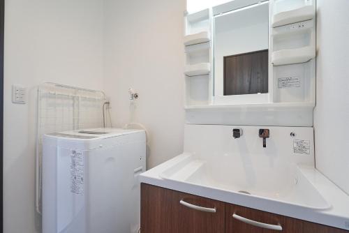 baño blanco con fregadero y nevera en 08 Resort Club -Theater-, en Fujikawaguchiko
