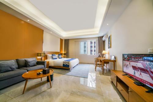 a living room with a couch and a tv at Mekong River Jing Land Hotel in Jinghong