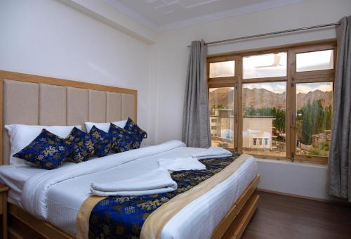 a bedroom with a large bed and a window at The Nangsay Hotel in Leh