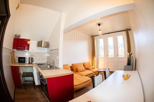 a small kitchen and living room with a couch at SUITE dans VILLA MEXICAINE in Jausiers