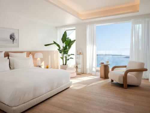 a bedroom with a white bed and a large window at The Roc Club in Athens