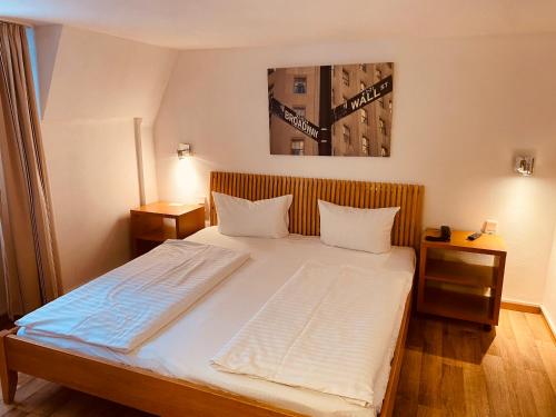 1 dormitorio con 1 cama grande con sábanas blancas en Stay Inn Central Station en Frankfurt