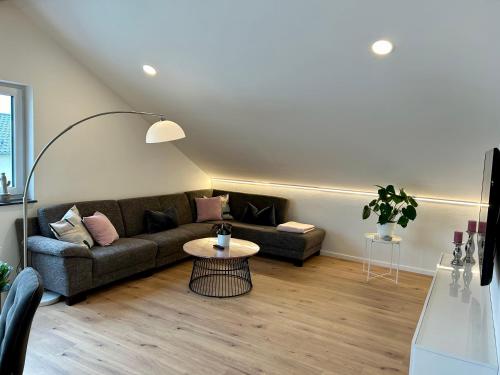 a living room with a couch and a table at Allgäu Zimmer LeAndi in Memmingen