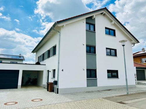 a white building with a garage at Allgäu Zimmer LeAndi in Memmingen