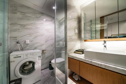 a bathroom with a washing machine and a sink at Mekong River Jing Land Hotel in Jinghong