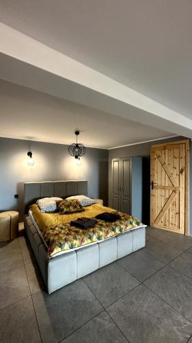 a bedroom with a large bed with a wooden door at Domki Na Złotym Groniu in Istebna