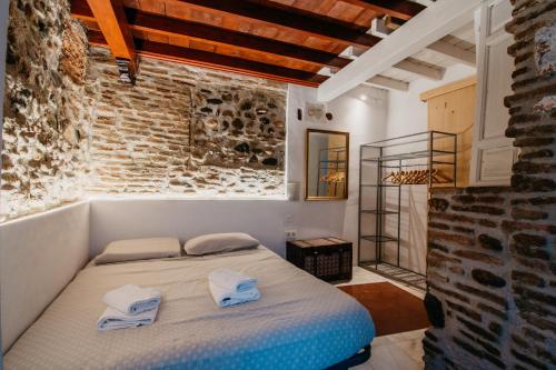 グラナダにあるtuGuest House Albaicínのレンガの壁にベッド1台が備わるベッドルーム1室