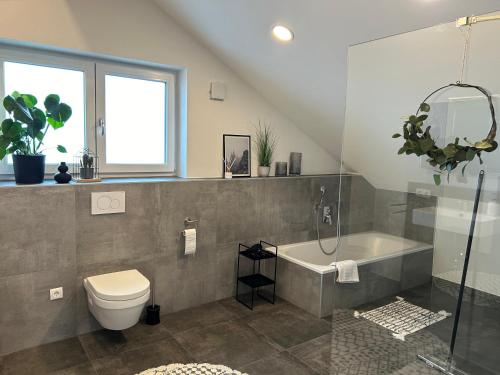 a bathroom with a toilet and a bath tub at Allgäu Zimmer LeAndi in Memmingen