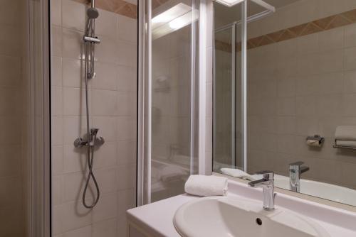 a bathroom with a sink and a shower at The Originals Boutique, Hôtel Cassitel, Cassis in Cassis