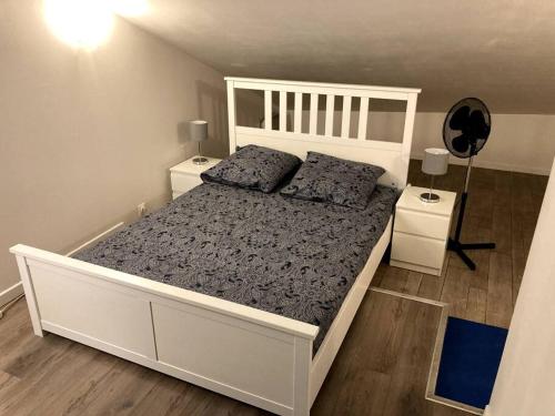1 dormitorio con 1 cama blanca grande y 2 mesitas de noche en Duplex rare avec terrasse vue à 360 Théâtre, en Orange