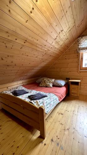 a bed in a wooden room in a cabin at Domki Na Złotym Groniu in Istebna