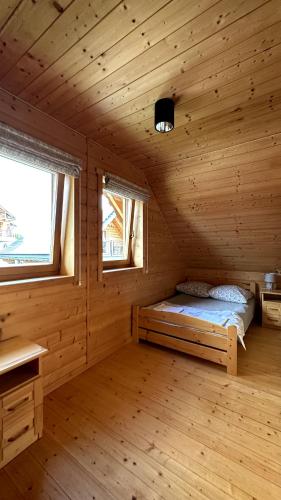 a bedroom with a bed in a wooden cabin at Domki Na Złotym Groniu in Istebna