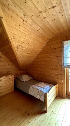 a wooden cabin with a bed in a room at Domki Na Złotym Groniu in Istebna
