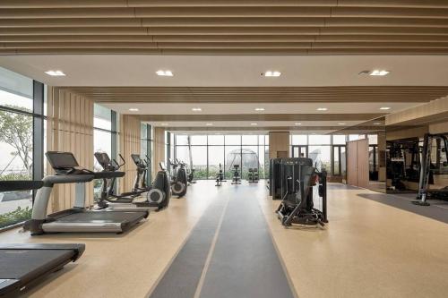 Un gimnasio con cintas de correr y equipos de ejercicio en un edificio. en Luxury Condo In Metropole Thu Thiem Sai Gon, en Ho Chi Minh