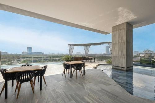 Un patio con mesas y sillas y vista a la ciudad. en Luxury Condo In Metropole Thu Thiem Sai Gon, en Ho Chi Minh