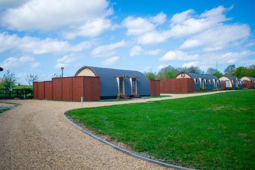 um grupo de edifícios num campo com uma estrada em Dragons Den em Norwich