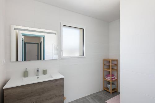 bagno con lavandino e specchio di Maison du Cap - Morgat - 5min Plage a Crozon