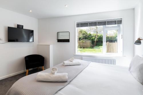 a white bedroom with a bed with towels on it at The Nook - Self Serviced Accommodation in St Ives
