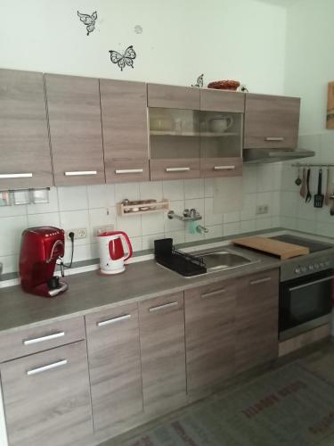 uma cozinha com armários de madeira e um aparelho vermelho em Ferienwohnung Taube 