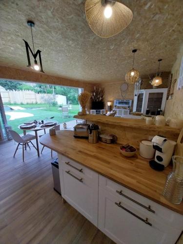 a kitchen with a counter and a table in a room at Le Clos FMR Insolite - "F"anny Carcassonne in Malves-en-Minervois
