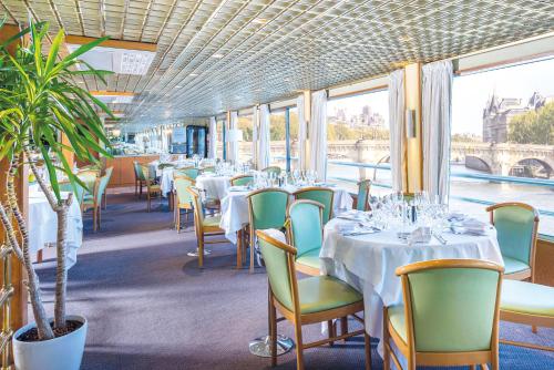 un wagon-restaurant d'un train avec des tables et des chaises dans l'établissement Bateau Botticelli by CroisiEurope, à Paris