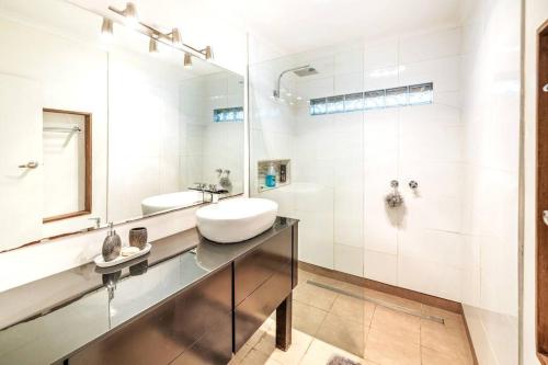 a white bathroom with a sink and a mirror at Charming Home Near Melbourne Airport & CBD in Melbourne