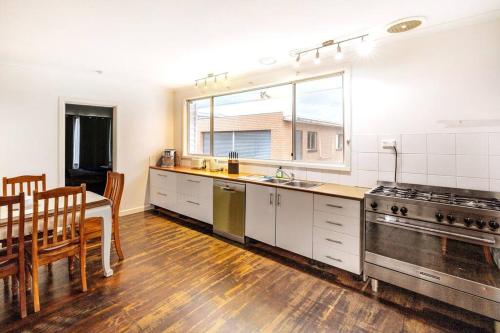 a kitchen with a table and a dining room at Charming Home Near Melbourne Airport & CBD in Melbourne