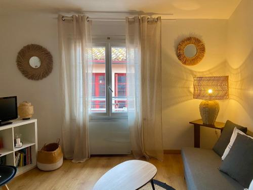 sala de estar con sofá y ventana en Appartement rénové à 50 m de COLLIOURE Plage, Entrée autonome, Climatisé, en Collioure