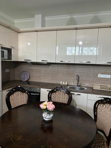 a kitchen with a table with a vase of flowers on it at Apartmani "MARIJA" Golubac in Golubac