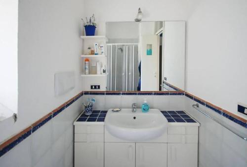une salle de bains avec un lavabo blanc et un miroir dans l'établissement villa Il Gelsomino, à Termini