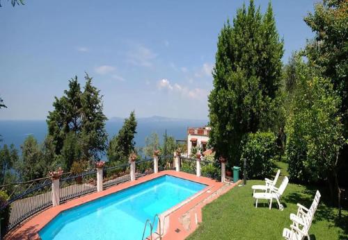 une piscine dans une cour avec des chaises et une maison dans l'établissement villa Il Gelsomino, à Termini