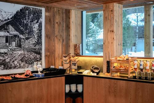 a restaurant with wooden walls and a counter with food at Hotel Pozzamanigoni in Selva di Val Gardena